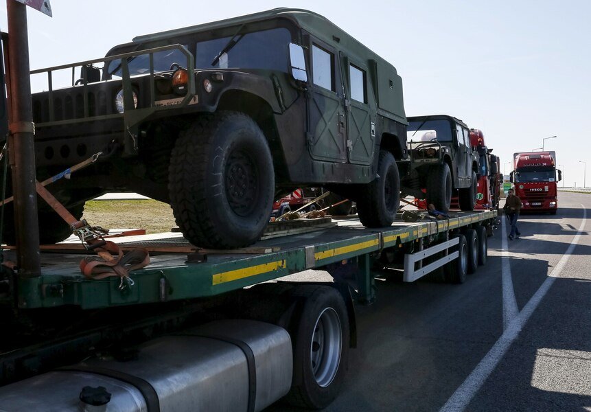 Trucks transport U.S. army military vehicles on the road near the Polish-Ukrainian border in Krakovets